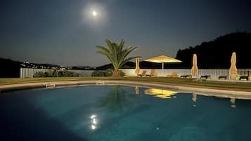 Een seizoensgebonden buitenzwembad en parasols bij het zwembad