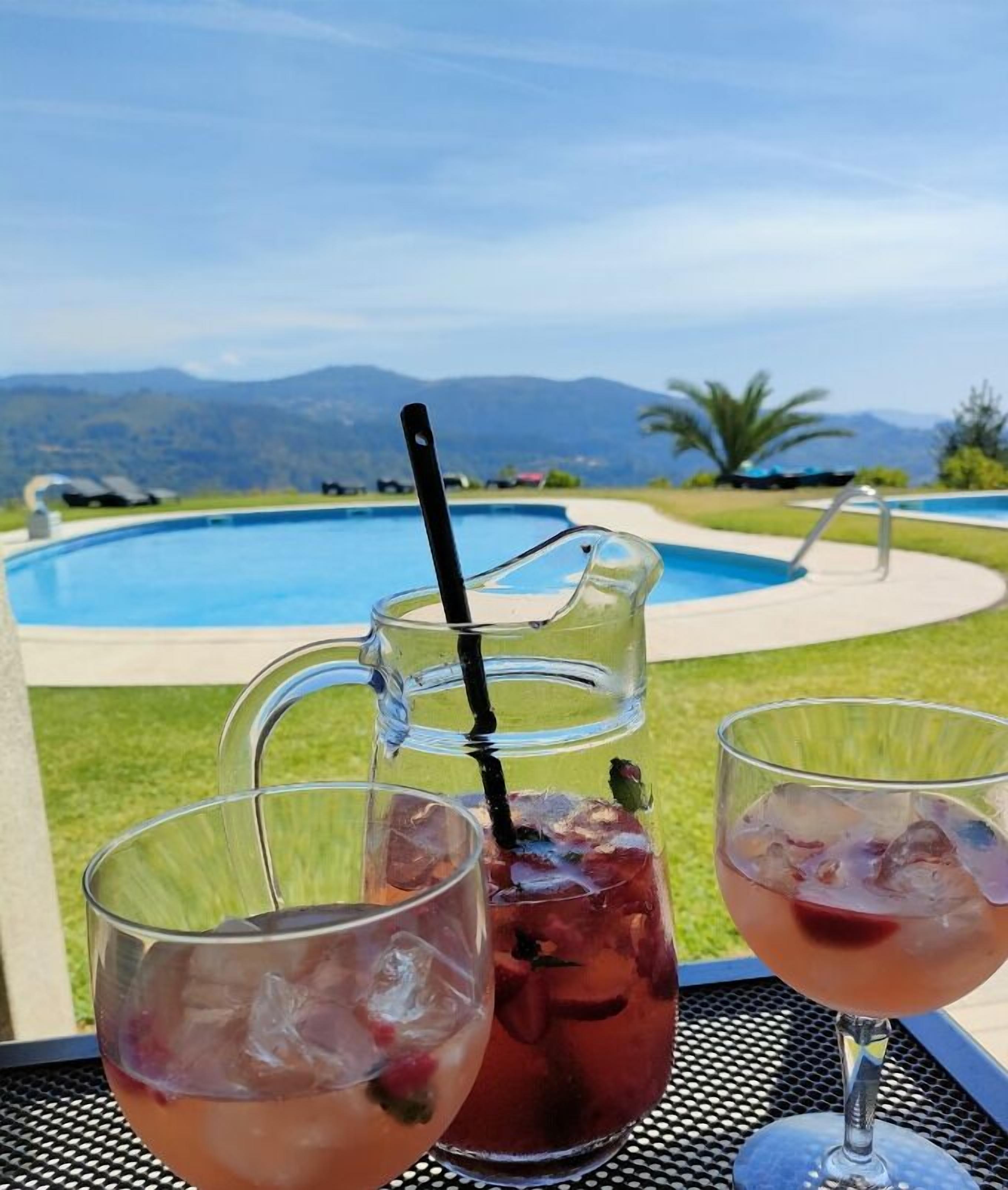 Un entorno junto a la piscina con vistas despejadas a una pileta y montañas al fondo.