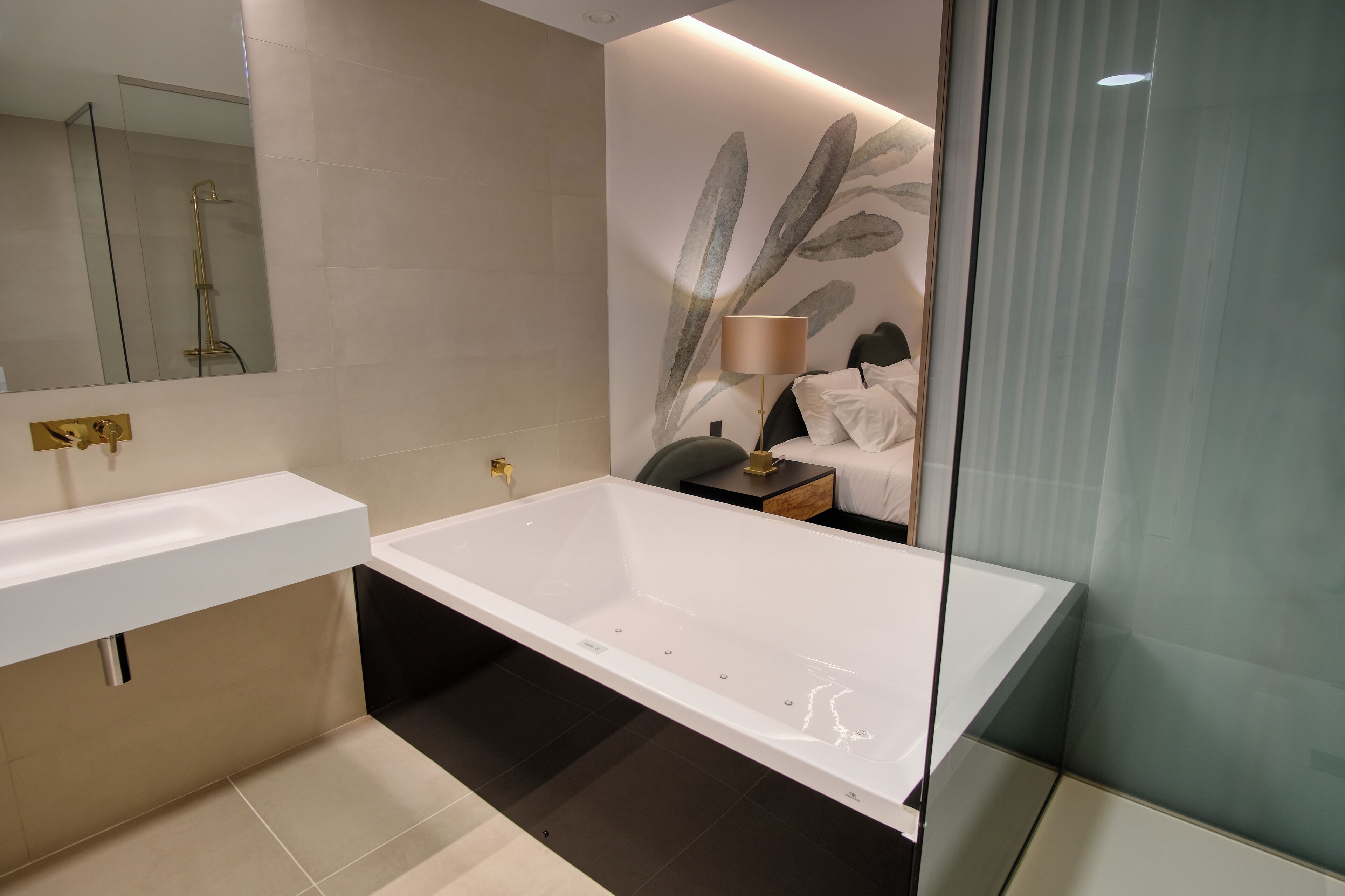 A modern bathroom with a large white bathtub, a glass shower enclosure, and a minimalist design.