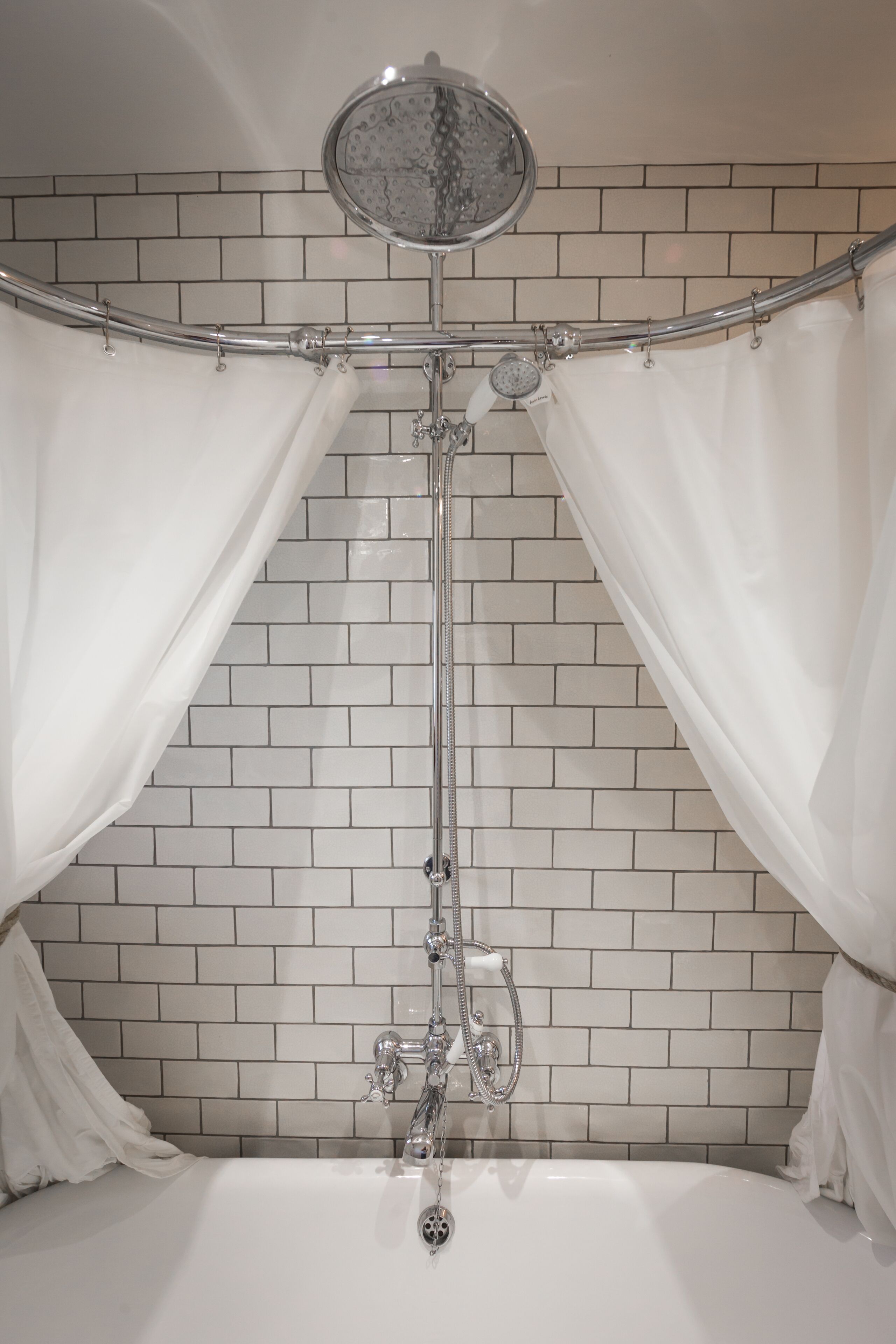Une salle de bain avec une baignoire, une douche et un mur carrelé.