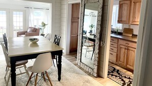 Un espace repas comprenant une grande table, des chaises et un miroir décoratif.