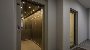 An elevator with a glass door, a control panel, and a fire alarm. - Modern  apartment located in central Reykjavik. - Studio 2 (Reykjavík)