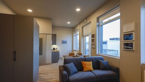 A modern living room with a sofa, a dining area, and a kitchen in the background. - Modern  apartment located in central Reykjavik. - Studio 2 (Reykjavík)