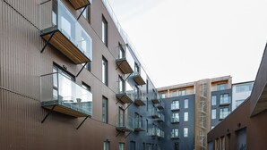 A modern building with multiple balconies, a paved walkway, and a grassy area. - Modern  apartment located in central Reykjavik. - Studio 3 (Reykjavík)