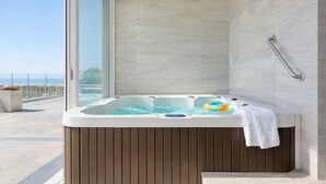 A modern bathroom with a hot tub, a glass shower enclosure, and a view of the sea. - 6th-Floor Oceanfront Condo - Indoor Pools, Sauna, Private Beach (Rosarito BC)