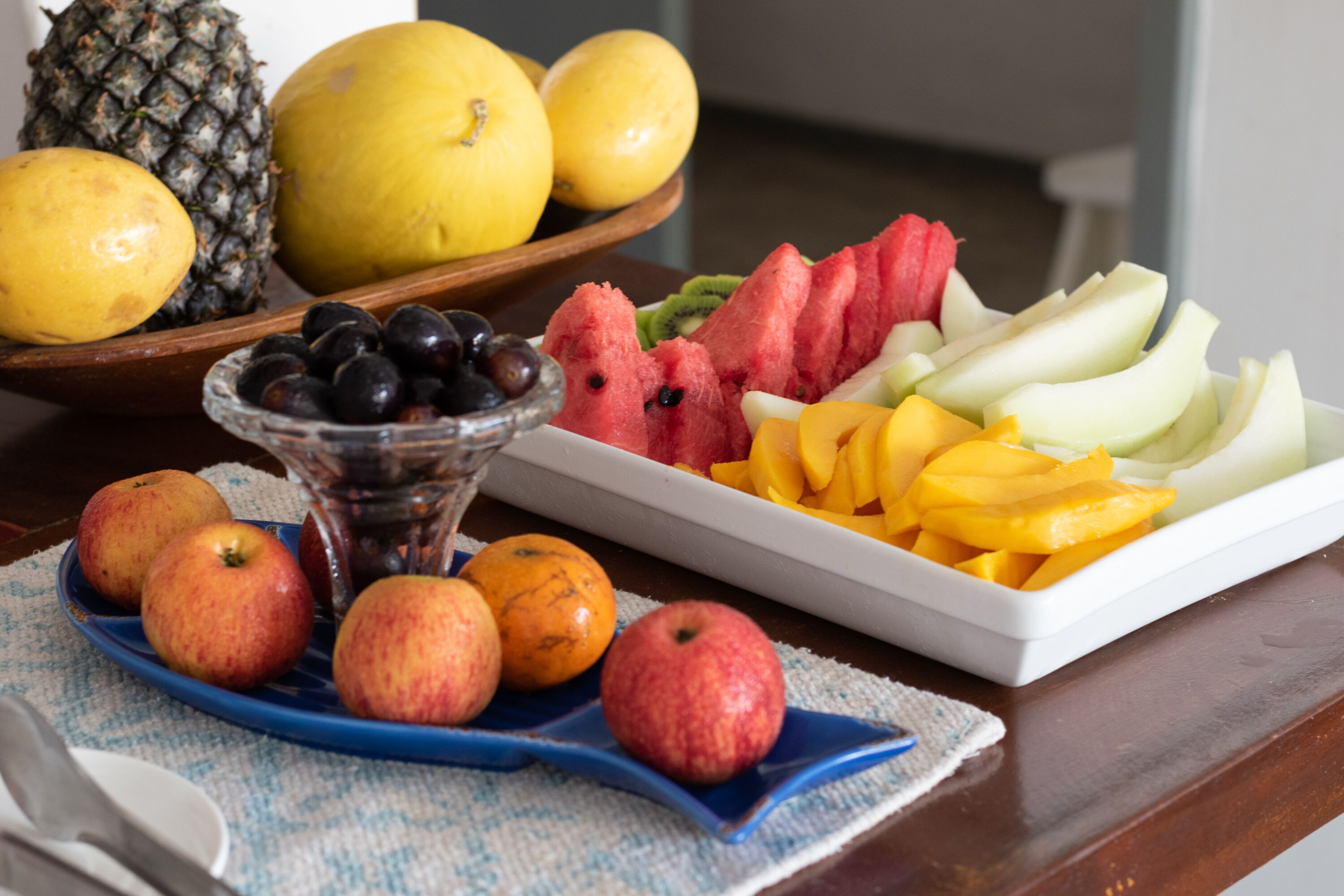 A fruit platter with apples, oranges, and various fruits like watermelon and mangoes.