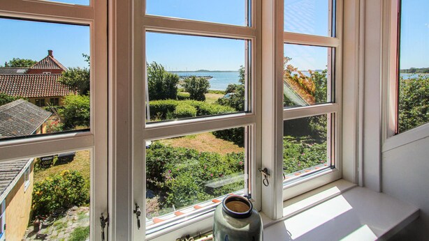 A window with a view of a garden and a body of water. - Beautiful home in Samsø with WiFi (Samsø)