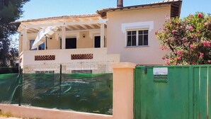 A two-story building with a covered patio area, a swimming pool, and a green fence. - 2 bedroom beach front home in Cagnes-sur-mer (Cagnes-sur-mer)