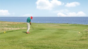 Un campo de golf con vistas al océano.