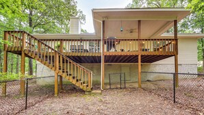 Eine zweistöckige Holzterrasse mit einer Treppe, die zu einem überdachten oberen Bereich führt.