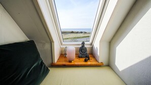 Ein kleiner Raum mit Oberlichter, der Blick auf einen Strand geht.