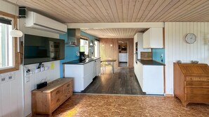 A compact kitchen with a central island, wooden cabinets, and a microwave. - Amazing home in Aabenraa (Aabenraa)