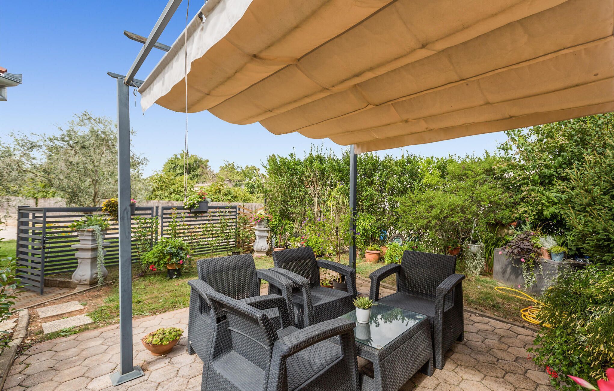 An outdoor patio with wicker furniture and a canopy.