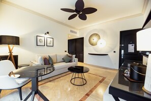 Uma sala de estar moderna com um sofá, mesa de centro e ventilador de teto.