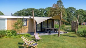 A modern outdoor patio with a table and chairs, surrounded by a wooden fence and greenery. - Lovely home in Voorthuizen with WiFi (Voorthuizen)