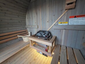 A sauna room with wooden benches, a bench with a heater, and a caution sign warning about fire risk. - Sedona Epic Dream 5BR 2xPool w/Slide Rooftop Hottub / Sauna / Firepit (Sedona)