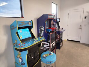 A room with arcade machines, including 'The Simpsons' and 'Terminator Judgment Day' games, and a small stool with 'Arcade Up' branding. - Sedona Epic Dream! 5BR Pool/Slide/Spa/Sauna! (Sedona)