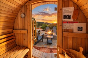 A sauna with wooden walls, a clock, and a warning sign.