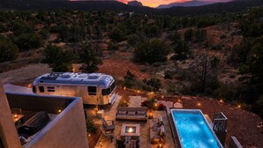 A recreational vehicle with a covered living area, a pool, and outdoor seating.