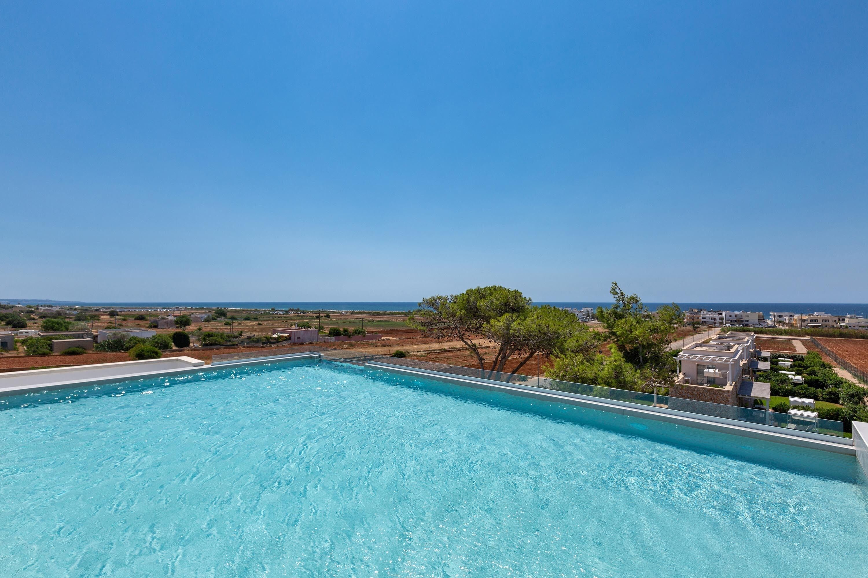 Une piscine sur le toit offrant une vue dégagée sur la mer et le paysage environnant.