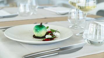 A dessert on a plate with a wine glass and a water glass in the background.