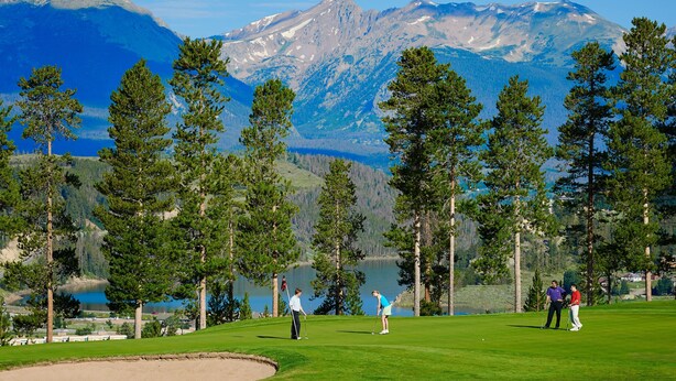 A golf course with a lake and mountains in the background. - 2BR/2BA Condo on Shuttle Route - Wild Irishman 1015 - Pool & more! (Keystone)