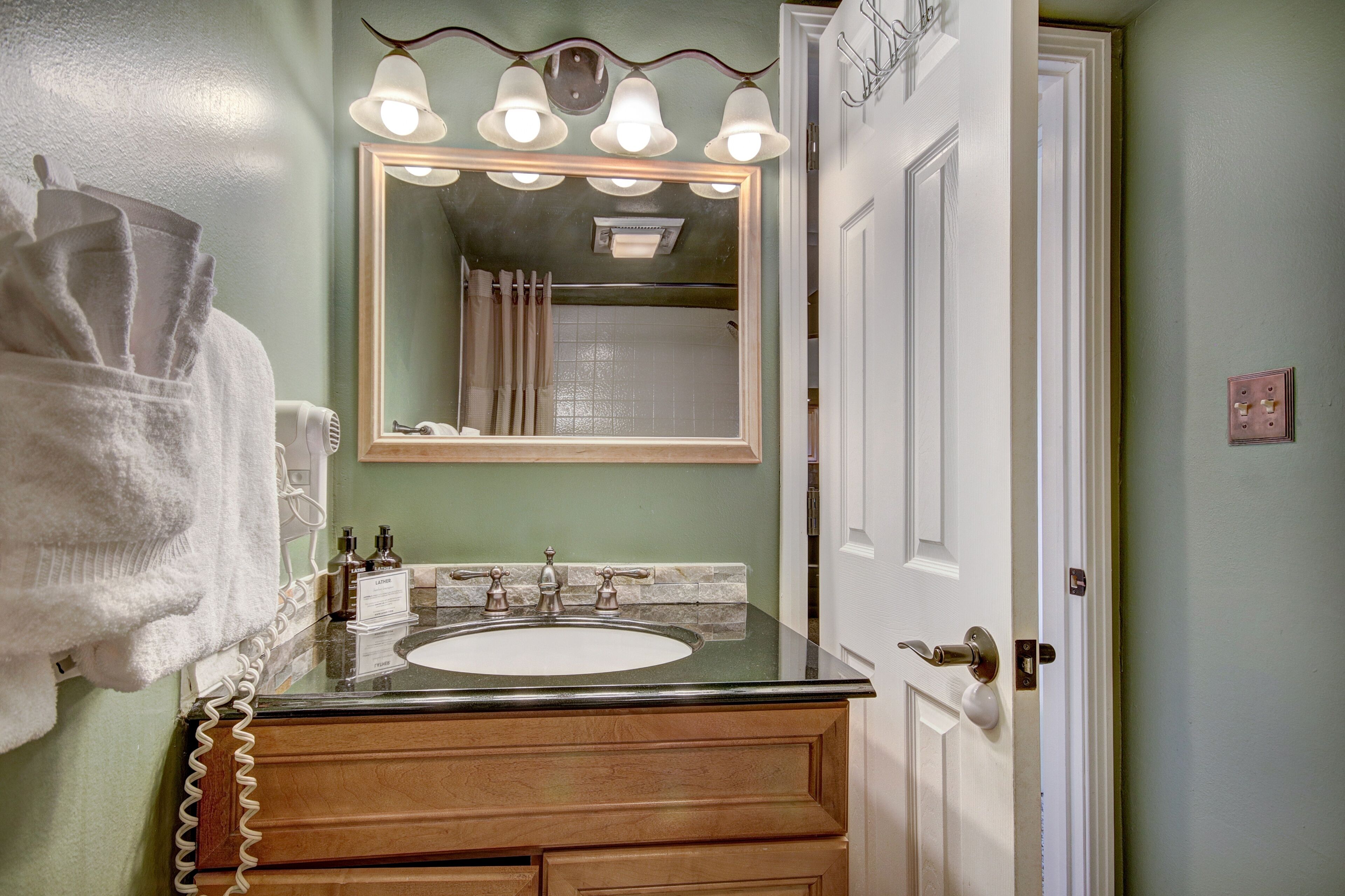 A bathroom with a sink, mirror, and towel rack.