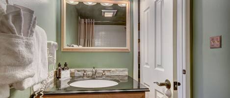 A bathroom with a sink, mirror, and towel rack.