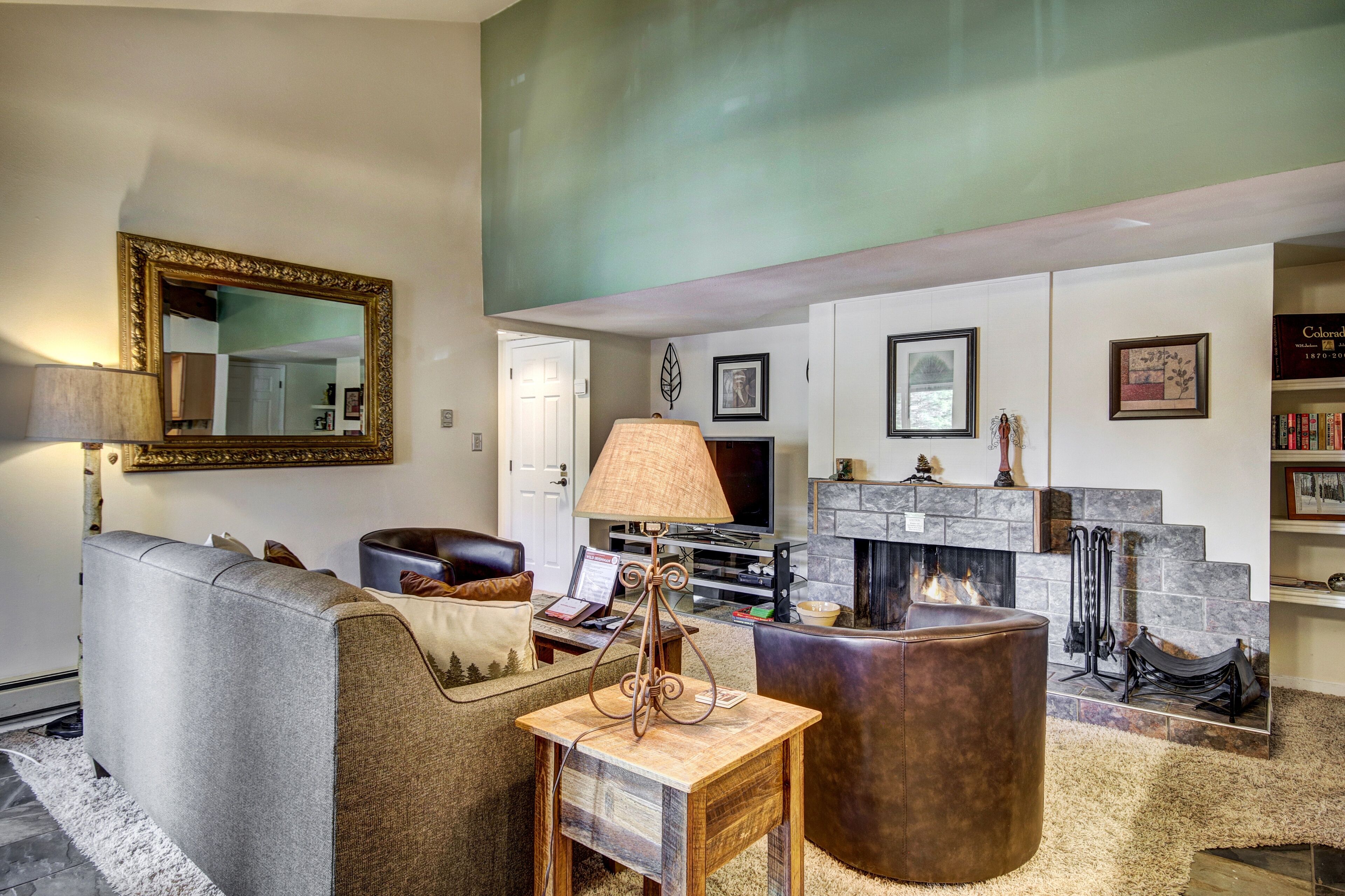 A living room with a fireplace, a sofa, a coffee table, and a television.
