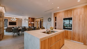 Een moderne keuken met een centraal eiland, houten kastjes en ingebouwde apparatuur.