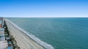 A coastal hotel with a beachfront view, including a pool area and a promenade along the beach. - Beautiful Oceanfront Condo, breathtaking sunrises and a relaxing experience (Myrtle Beach)