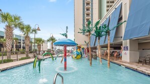 A swimming pool with water slides and palm trees. - Beautiful Oceanfront Condo, breathtaking sunrises and a relaxing experience (Myrtle Beach)