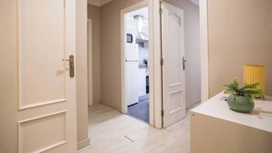 Um corredor com uma porta branca que dá para uma cozinha.