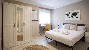 Um quarto com uma cama, uma escrivaninha e um guarda-roupa.