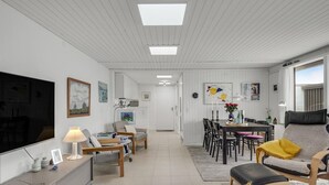 A spacious living area with a dining table, chairs, and a kitchen in the background. - Awesome home in Pandrup with WiFi (Pandrup)