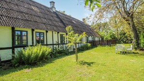 A traditional house with a thatched roof, a well-maintained garden, and a bench. - Awesome home in Samsø with WiFi (Samsø)