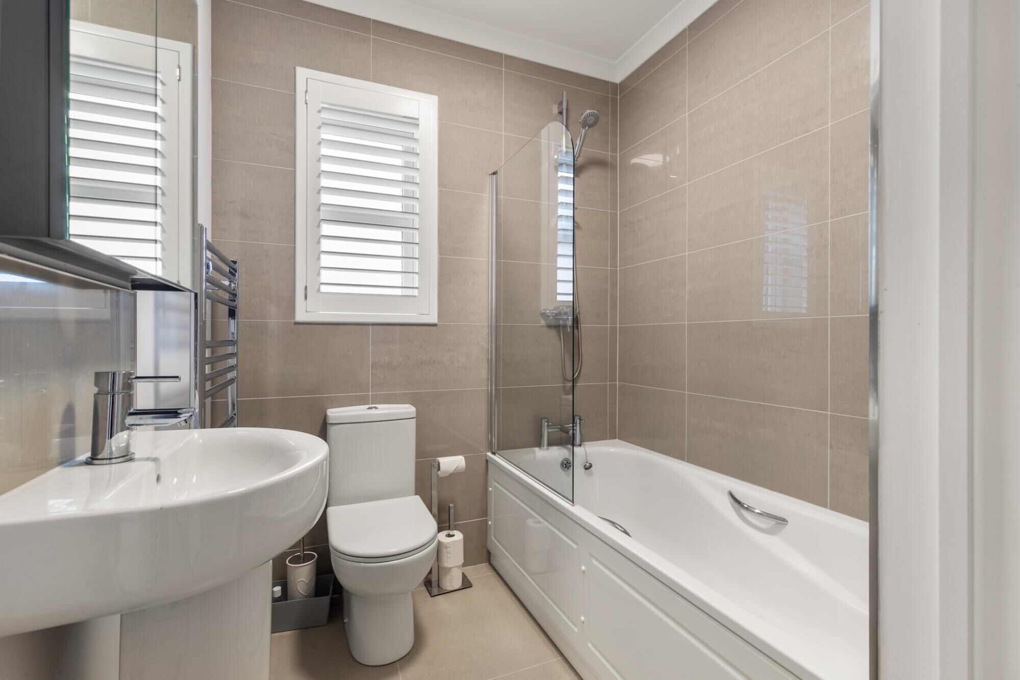 Een moderne badkamer met een wastafel, toilet en bad.