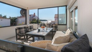 A balcony with a table and chairs, a sofa, and a view of the sea. - Amazing apartment in Pakostane with WiFi (Pakostane)
