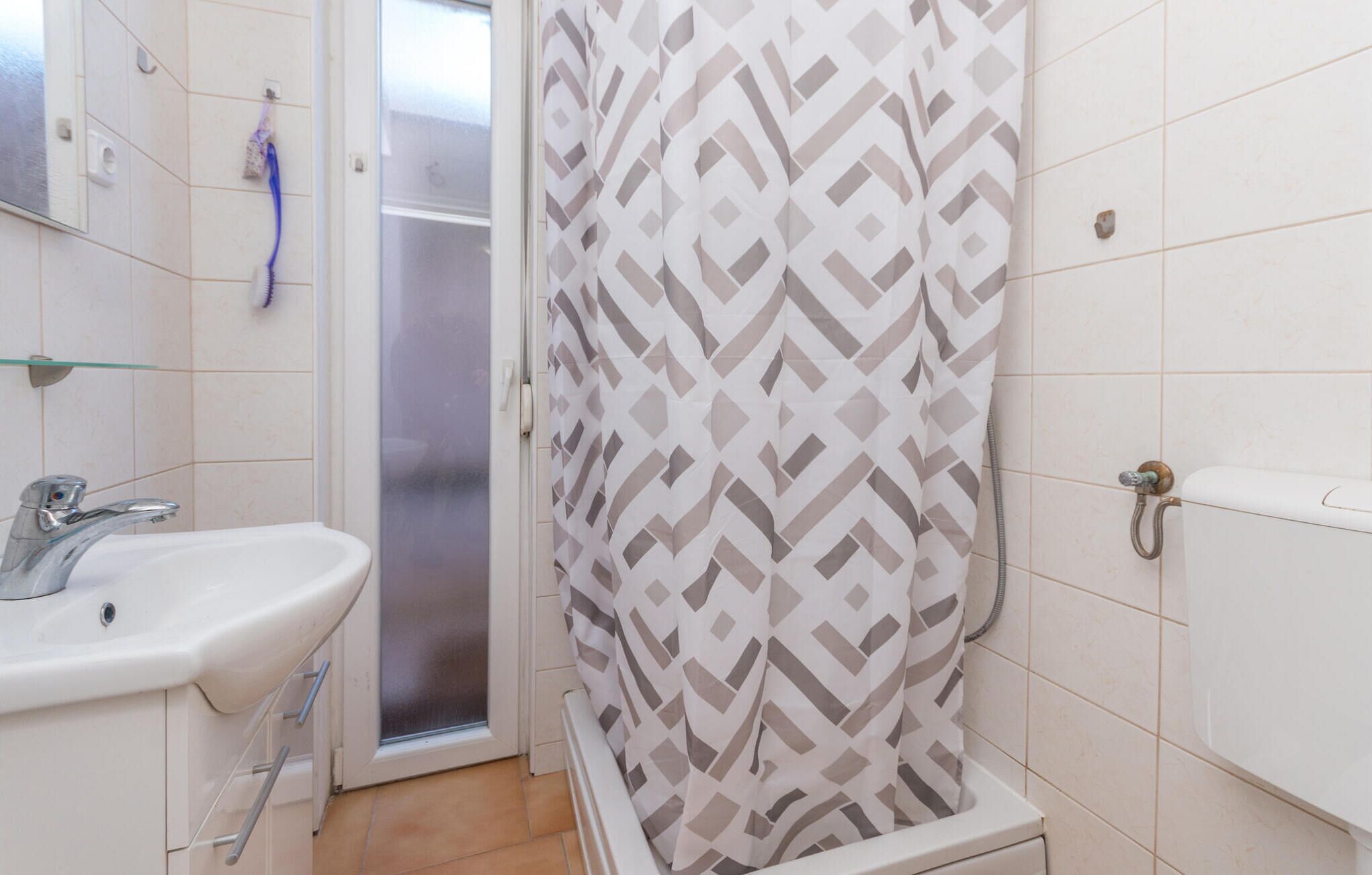 Un baño con ducha, lavamanos e inodoro.