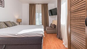 A hotel room with a bed, a sofa, a TV, and curtains. - Amazing apartment in Pakostane with WiFi (Pakostane)