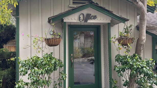 A small building with a green door and the word "Office" above it.
