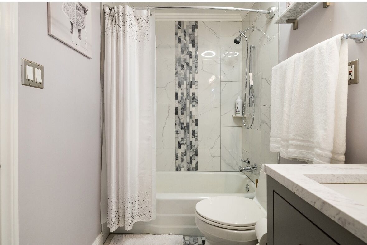 Une salle de bain avec douche, toilettes et lavabo.