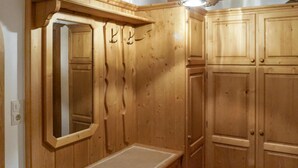 Une armoire en bois avec un miroir et un petit banc.