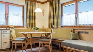 Une pièce chaleureuse avec une table et des chaises en bois, un banc et un radiateur.