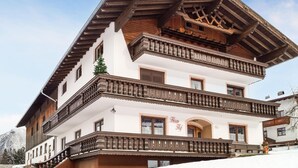 Un immeuble à plusieurs étages, doté de balcons en bois et présentant un style architectural traditionnel.