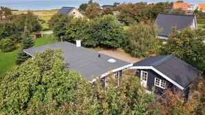 Et boligområde med huse, en græsplæne og havudsigt.