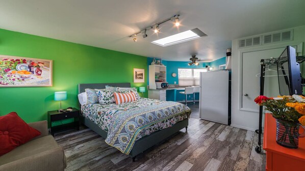 Cozy retreat with a bed, nightstand, and desk, perfect for a comfortable stay.