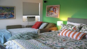 Guest room with a floral-patterned bedspread, two pillows, and framed artwork.