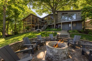 A modern house with a fire pit and outdoor seating.