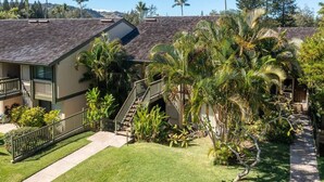 A residential area with houses featuring steep roofs and a well-maintained lawn. - Spacious 1 Bedroom Condo at Turtle Bay (Kahuku)